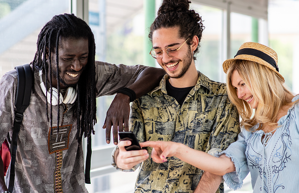Three friends looking at a smartphone together